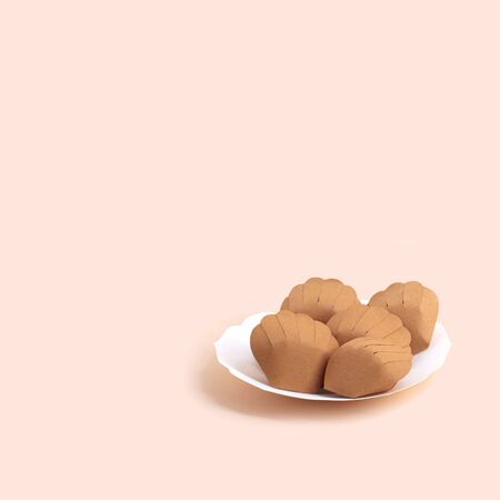 Paper plate with madeleine. Popular french small shell-shaped cake. Paper art and craft. Volumetric handmade paper objects. Minimal art food concept. Square imageの写真素材