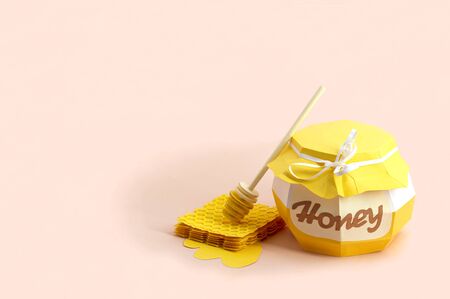 Paper pot with honey, honeycombs and dipper. Paper art and craft. Volumetric handmade paper objects. Minimal healthy eating conceptの写真素材