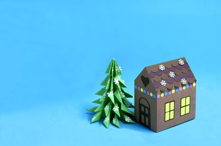 Paper gingerbread house and Christmas tree. Paper art and craft in festive design. Volumetric handmade paper objects. Minimal christmas conceptの写真素材