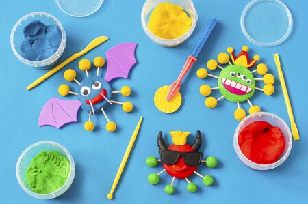 Child makes scary coronaviruses from modeling dough. Modeling from clay or dough, children's craft during quarantine. DIY. How to captivate children at home during coronavirus pandemicの写真素材