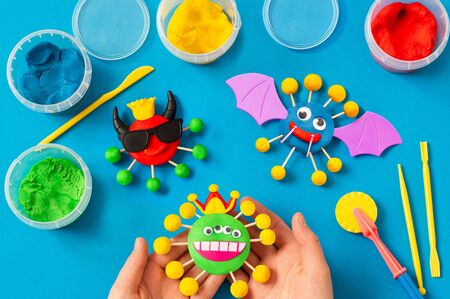 Child makes scary coronaviruses from modeling dough. Modeling from clay or dough, children's craft during quarantine. DIY. How to captivate children at home during coronavirus pandemic の写真素材