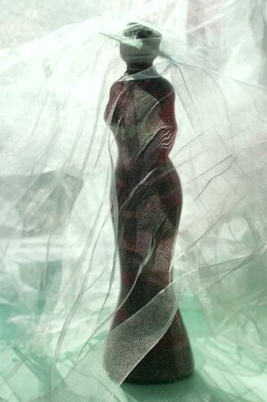 Decorative handmade bottle in shape of woman under veil. Elegant silhouette of woman in long dress. Modern pop art. Minimal symbolic home isolation concept during coronavirus Covid-19 pandemicの写真素材