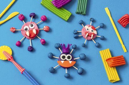 Child makes scary coronaviruses from plasticine. Plasticine modeling, children's craft during quarantine. DIY. How to captivate children at home during coronavirus pandemic の写真素材