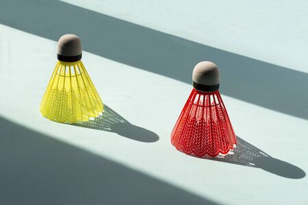 Colored shuttlecocks with long shadows as women walking along road. Metaphor of social distance during coronavirus pandemic. Creative presentation of information. Concept health careの写真素材
