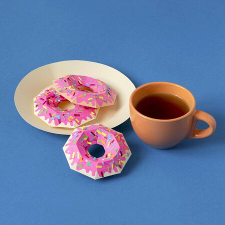Paper donuts and real cup of tea. Realistic handmade paper objects. Paper art and craft. Minimal art food conceptの写真素材