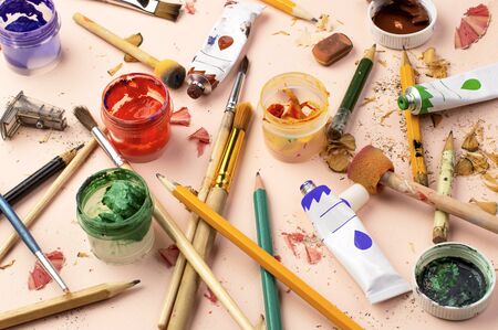 Clutter of art materials. Dried paints, disheveled brushes, broken pencils, pencil shavings. Tools...