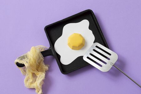 Cast-iron frying pan with paper fried eggs and spatula. Realistic handmade paper objects. Paper art and craft. Minimal art food conceptの写真素材