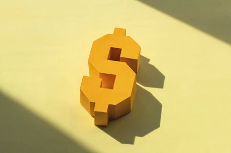 Lying paper dollar sign with big shadow. Concept of decline, falling dollar. Economic recession. Depreciation of national currency. Crisis and economic shock. Real volumetric handmade paper objectsの写真素材