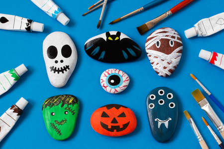 Drawing on stones Halloween characters. Art project for children. DIY concept. Halloween party decor. Skull, bat, mummy, stuffed animal, eye, pumpkin, monster painted on sea stonesの写真素材