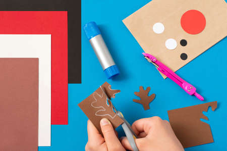 Child decorates craft gift bags for Christmas. Original project for children. DIY concept. Step-by-step photo instructions. Step 7. Cut detailsの写真素材