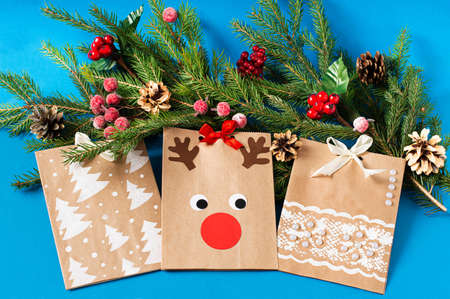 Child decorates craft gift bags for Christmas. Original project for children. DIY concept. Step-by-step photo instructions. Step 9. Final resultの写真素材