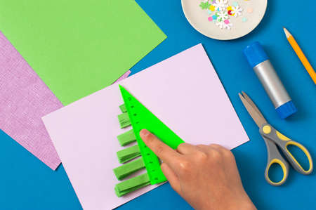 How to make Christmas card with volumetric tree. Original project for children. DIY concept. Step-by-step photo instructions. Step 7. Glue stripes on one half of cardの写真素材