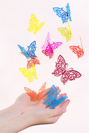 Openwork paper butterflies fly out of girl's hands. Paper art and craftの写真素材