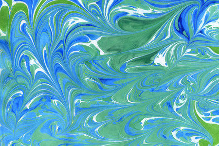 Abstract handmade background in ebru technique. Paper surface with an imprint of paints on water. Blue curls, waves and spots of different shapes and sizes. Unique art illustrationの写真素材