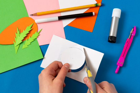 Child makes Easter greeting card. Art project for children. DIY concept. Step-by-step photo instruction. Step 7. Cut circleの写真素材