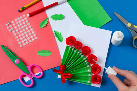 Child makes greeting card for Mother's Day. Art project for children. DIY concept. Step-by-step photo instruction. Step 14. Glue roseの写真素材
