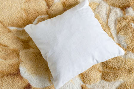 White pillow mockup on background of fur blanket. Clean white pillow, bedding design mockup. Blank surface, top view, copy spaceの写真素材