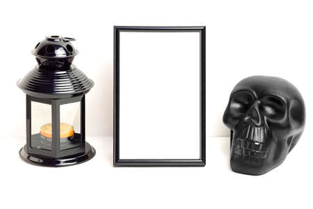 Mockup photo frame with skull and black lantern with candle. Empty photo frame mockup for showcasing Halloween art and photo projectsの写真素材