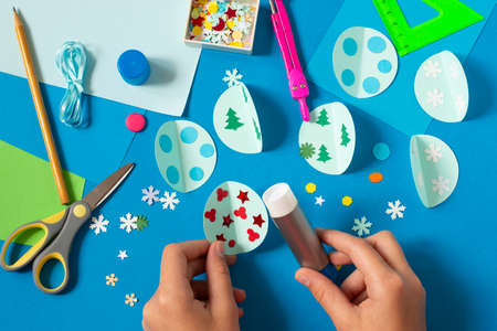 Making Christmas card with volumetric Christmas ball. Original project for children. DIY concept. Step-by-step photo instructions. Step 6. Glue decorationsの写真素材
