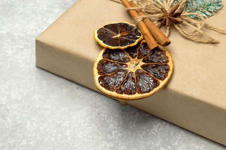 Close-up gift box decorated with dried orange slices, cinnamon and star anise. Eco-friendly reusable paper gift box with natural edible decorationsの写真素材
