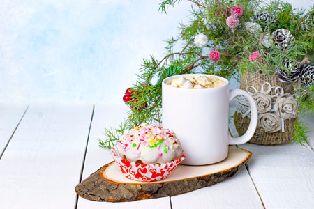 Hot chocolate with marshmallows, festive muffin with frosting and colored sugar, handmade Christmas bouquetの写真素材