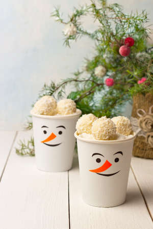 Coconut cream dessert in paper cups as funny snowmen. Homemade application paper cups. Idea for children's Christmas party. DIY concept of Merry Christmas and Happy New Yearの写真素材
