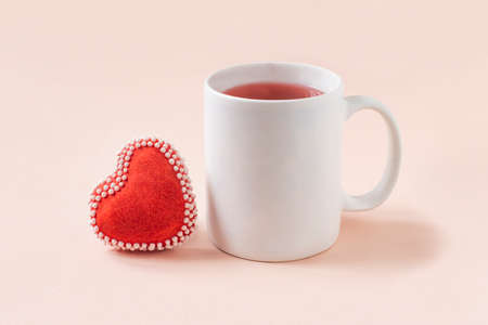 White mug mockup and handmade heart shaped gingerbread with icing. Mockup for Valentine's Day or birthday designの写真素材