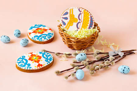 Colorful painted Easter egg-shaped gingerbread in basket and on table. Gingerbread cookies are...
