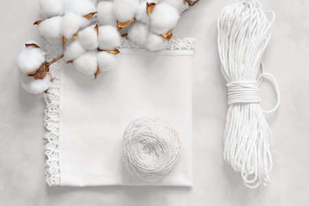 White cotton napkin with handmade knitted lace, cotton threads and cord, cotton sprig. Eco-friendly natural materials for handicraftの写真素材