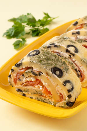 Festive egg roll with olives and herbs stuffed with salmon and cream cheese. holiday party appetizerの写真素材