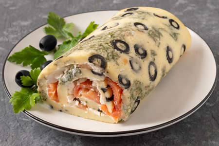 Festive egg roll with olives and herbs stuffed with salmon and cream cheese. holiday party appetizerの写真素材