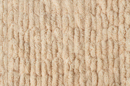 Abstract knitted background. Texture of fabric from thick plush threads for knitting by fingers. Soft fluffy fabricの写真素材