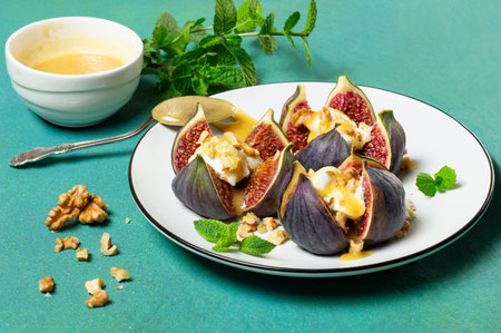 Ripe figs stuffed with cream cheese with honey sauce and walnuts. Delicious appetizer, perfect aperitif or fruity dessertの写真素材