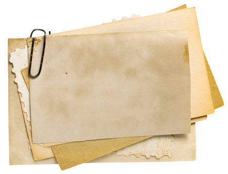 Stack of old blank yellowed photos with metal clip isolated on white backgroundの写真素材