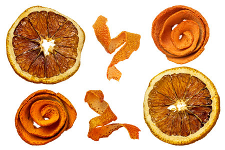 Round orange dried slices and twisted strips of orange peel close-up isolated on white backgroundの写真素材
