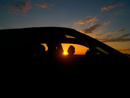 women in the car against the sun-downの写真素材