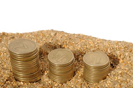 money coins pyramids in the sand isolated on white. time is money conceptの写真素材