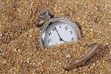 vintage pocket watch in the sand. time concept