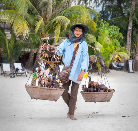 Koh Chang, THAILAND - MARCH 12: An elderly woman sells to tourists souvenirs on the beach, Thailand, on March 12, 2015.のeditorial素材