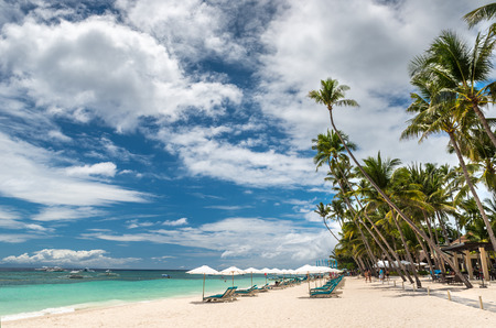 Tropical beach background from Alona Beach at Panglao Bohol island with Beach chairs on the white...