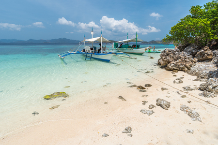 View of boats at tropical beach on the Bulog Dos Island, Philippines. Beautiful tropical island with sand beach, palm trees. Travel conceptの写真素材
