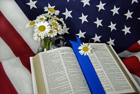 Open Bible and daisies on an American flagの写真素材