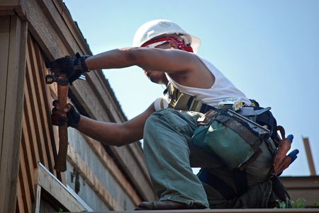 Worker using a hammer on the roof.