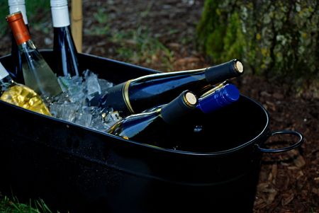 Wine bottles being iced down in a tub.の写真素材
