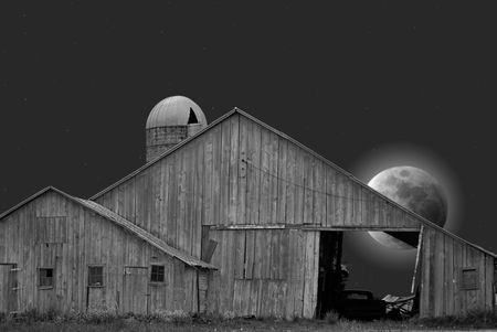 Full moon behind a dilapidated barn.の写真素材
