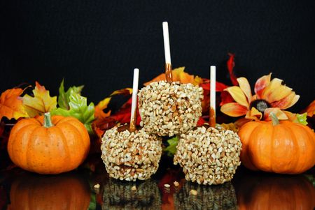 Stack of caramel apples and pumpkins with fall foliage.の写真素材