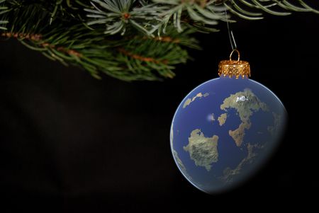 World ornament hanging from a Christmas tree bough.の写真素材