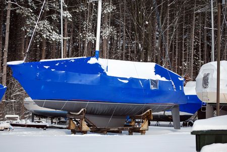 Bright blue tarp protecting a sailboat in winter.の写真素材