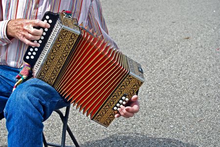 Elderly man playing a vintage accordion.