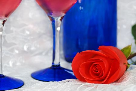 Rose with wine glasses and bottle on lace.の写真素材
